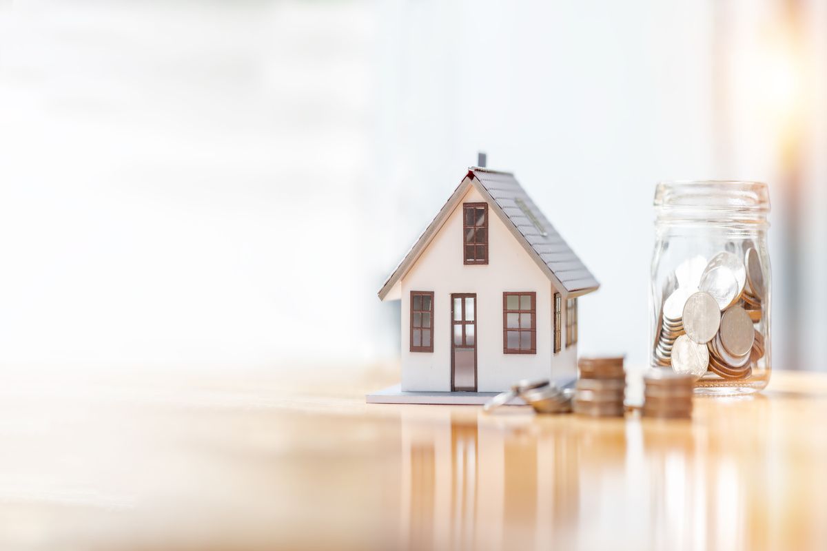 house model and money coins saving for concept saving money for buying a house, investment mortgage finance, and home loan refinance financial plan home loan.