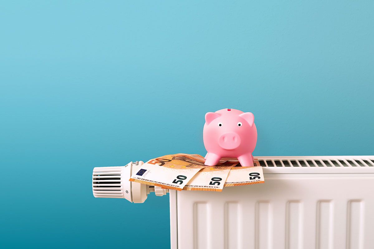 heating and energy costs, price increase, save money, piggy bank on radiator, Euro bank notes